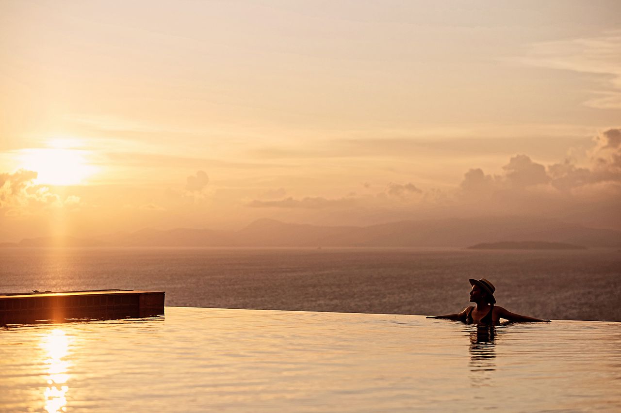 Alberca infinita de una villa en Los Cabos al atardecer, con el mar y la sierra al fondo