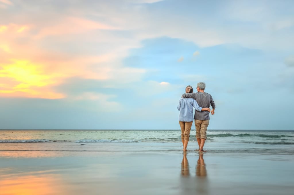 A couple walking a Los Cabos beach at golden hour