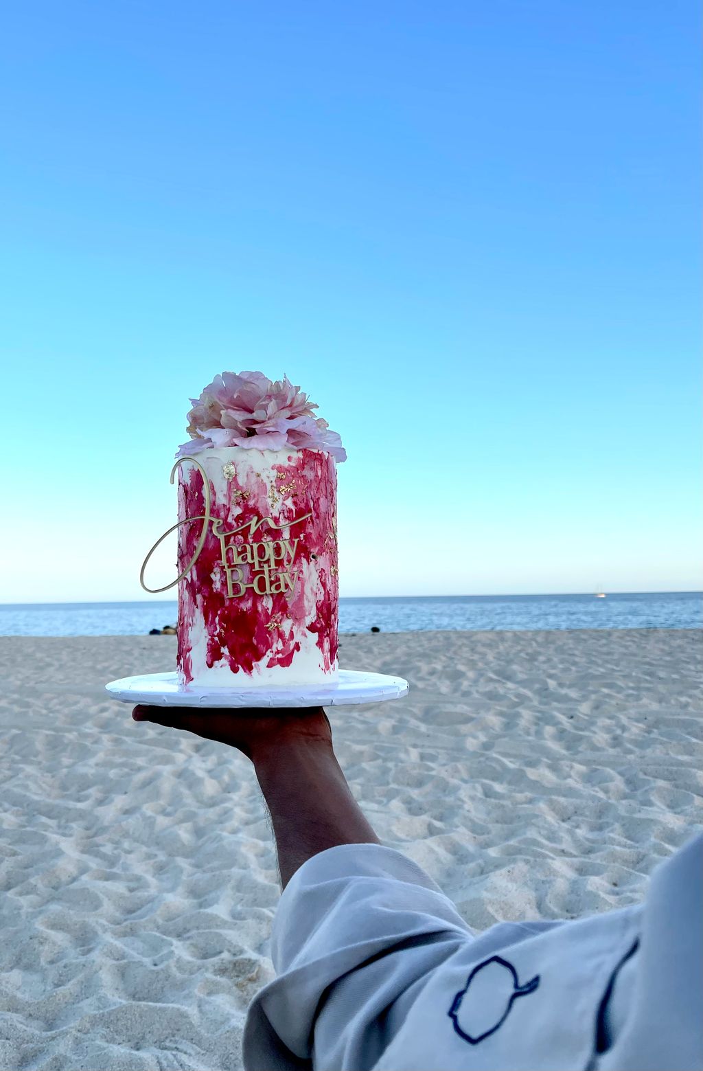 A bespoke celebration cake served on the beach at sunset in Los Cabos